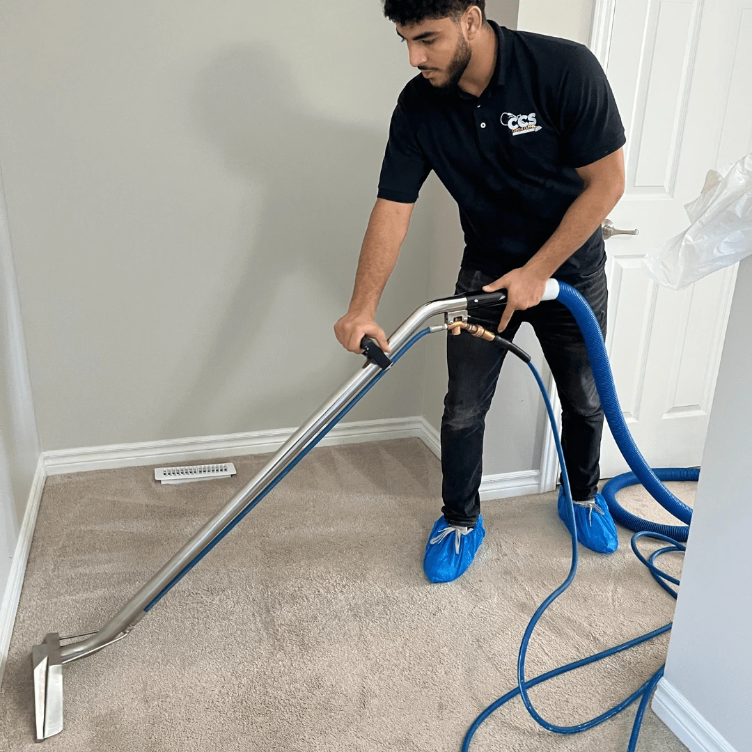 Technician performing Carpet Cleaning in a condo living room with extraction equipment